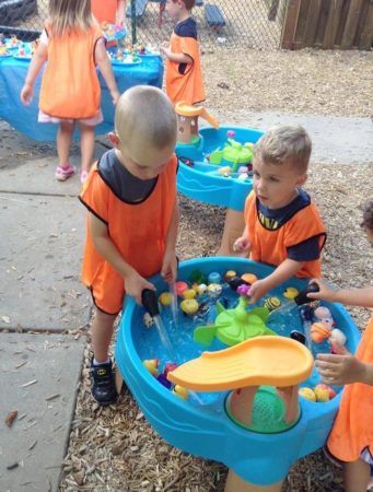 preschool_boys_playing_in_water_on_playground_cadence_academy_raintree_charlotte_nc-341x450