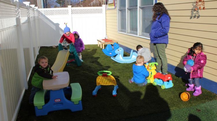 preschool_children_and_teacher_hanging_out_on_playground_cadence_academy_preschool_east_greenwich_ri-752x418