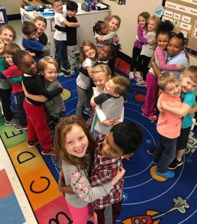 preschool_children_and_teacher_hugging_at_cadence_academy_preschool_summerville_sc-395x450