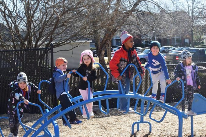 preschool_children_on_stegosaurus_playground_equipment_cadence_academy_preschool_mauldin_sc-675x450