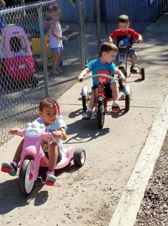 preschool_children_riding_tricycles_rogys_learning_place_east_peoria_il-335x450