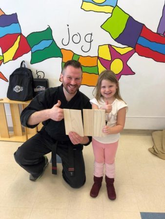 preschool_girl_and_karate_instructor_excited_after_board_break_learning_edge_childcare_and_preschool_oak_creek_wi-338x450