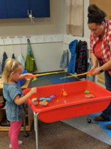preschool_girl_and_teacher_fishing_canterbury_academy_at_prairie_ridge_olathe_ks-338x450