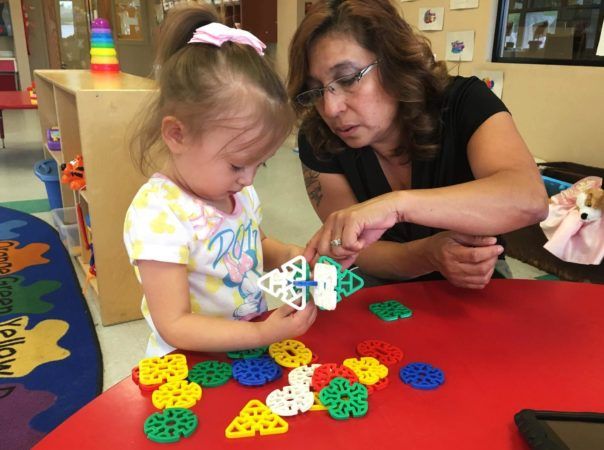 preschool_girl_and_teacher_playing_with_blocks_cadence_academy_preschool_smoky_hill_aurora_co-604x450