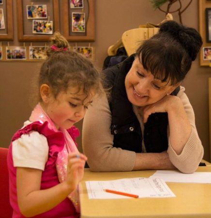 preschool_girl_and_teacher_working_on_writing_activity_cadence_academy_preschool_sherwood_or-436x450