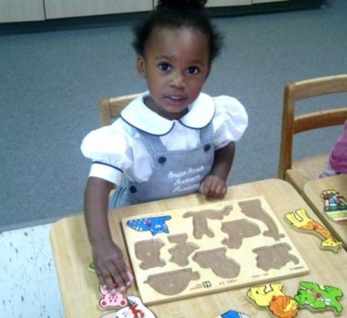 preschool_girl_doing_animal_puzzle_smaller_scholars_montessori_academy_grisby_tx-491x450