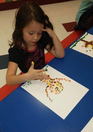 preschool_girl_doing_fingerpaint_at_cadence_academy_preschool_flower_mound_tx-318x450