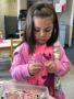 preschool_girl_doing_letter_necklace_cadence_academy_preschool_tumwater_wa-338x450