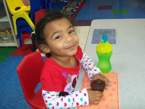 preschool_girl_enjoying_cupcake_creative_kids_childcare_centers_brewster-600x450