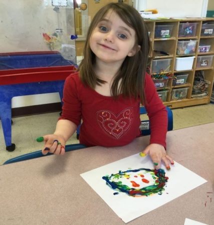preschool_girl_enjoying_finger_painting_activity_cadence_academy_preschool_westerly_ri-427x450