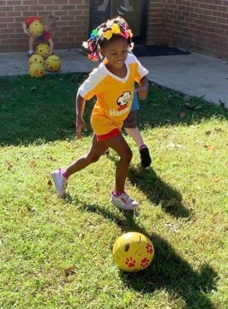 preschool_girl_enjoying_happy_feet_soccer_at_cadence_academy_preschool_charleston_sc-332x450