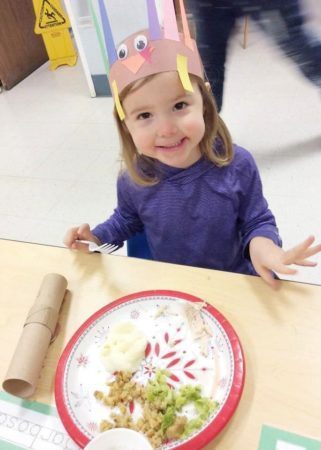 preschool_girl_enjoying_thanksgiving_dinner_at_cadence_academy_preschool_i_street_sacramento_ca-321x450