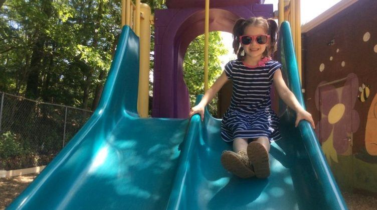 preschool_girl_going_down_slide_cadence_academy_preschool_seekonk_ma-752x418