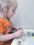 preschool_girl_looking_at_bug_specimens_rogys_learning_place_hilltop_peoria_il-338x450