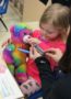 preschool_girl_nursing_rainbow_bear_back_to_health_cadence_academy_preschool_iowa_city_ia-324x450