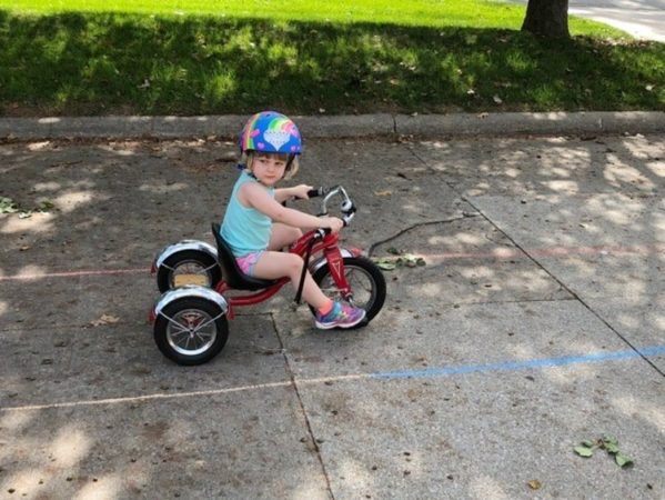 preschool_girl_on_tricycle_cadence_academy_preschool_grand_west_des_moines_ia-599x450