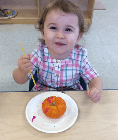 preschool_girl_painting_a_pumpkin_cadence_academy_preschool_urbandale_ia-380x450