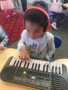 preschool_girl_playing_electric_piano_jonis_child_care_preschool_burlington_ct-338x450