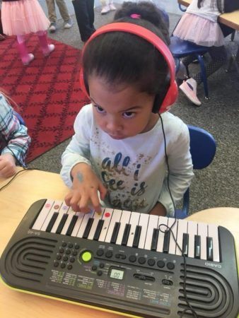 preschool_girl_playing_electric_piano_jonis_child_care_preschool_burlington_ct-338x450