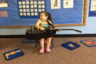 preschool_girl_playing_guitar_at_cadence_academy_preschool_seekonk_ma-675x450