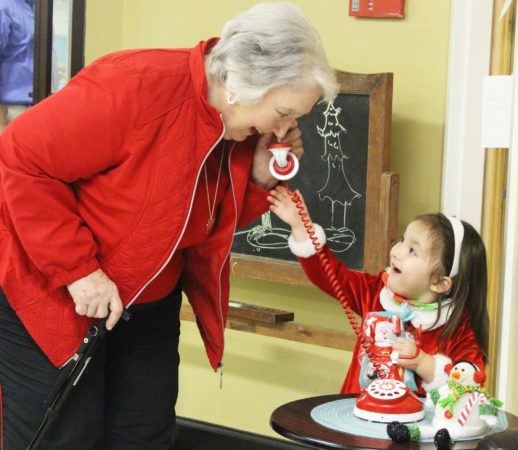 preschool_girl_playing_phone_with_grandmother_at_cadence_academy_preschool_lexington_sc-518x450