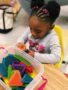 preschool_girl_playing_with_intersecting_blocks_cadence_academy_preschool_mount_pleasant_sc-338x450