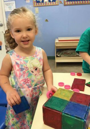 preschool_girl_playing_with_magnetic_squares_cadence_academy_preschool_grand_west_des_moines_ia-316x450