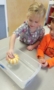 preschool_girl_playing_with_small_pumpkin_winwood_childrens_center_gainesville_va-270x450
