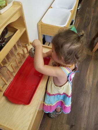 preschool_girl_pouring_childrens_garden_montessori-338x450