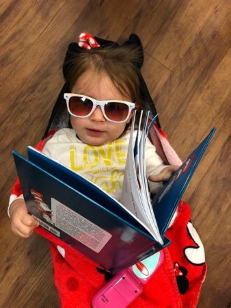 preschool_girl_reading_book_while_wearing_sunglasses_sunbrook_academy_at_woodstock_ga-338x450