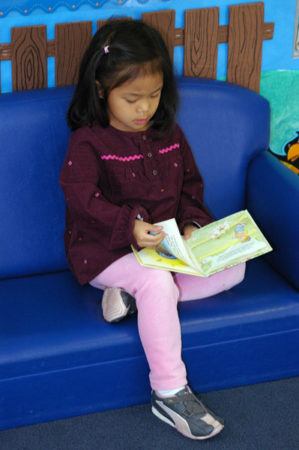 preschool_girl_reading_cadence_academy_preschool_fayetteville_ar-299x450