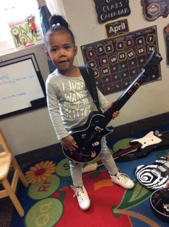 preschool_girl_ready_to_play_rock_band_rogys_learning_place_lake_street_peoria_heights_il-336x450