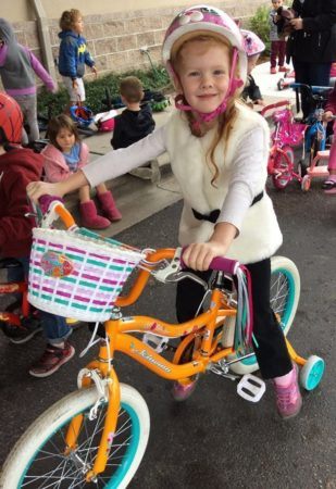 preschool_girl_riding_bike_for_st_jude_trike-a-thon_at_cadence_academy_preschool_columbine_littleton_co-309x450