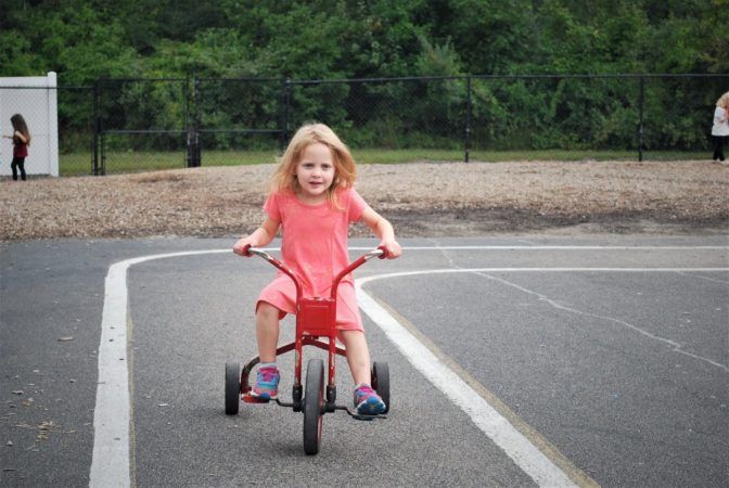 preschool_girl_riding_tricycle_at_next_generation_childrens_centers_franklin_ma-672x450