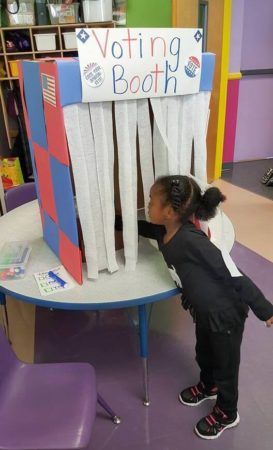 preschool_girl_voting_at_the_voting_booth_prime_time_early_learning_centers_middletown_ny-273x450