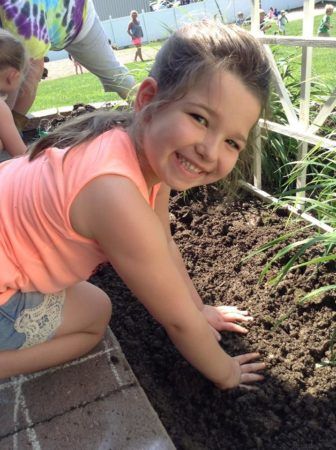 preschool_girl_working_in_the_garden_at_cadence_academy_collegeville_pa-336x450