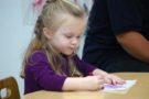 preschool_girl_writing_cadence_academy_preschool_fayetteville_ar