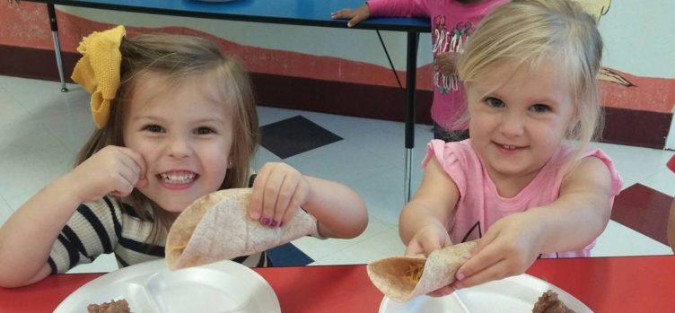 preschool_girls_eating_burritos_at_cadence_academy_preschool_flower_mound_tx-752x349