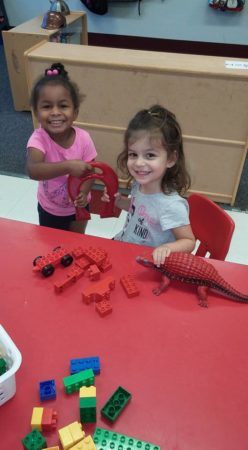 preschool_girls_playing_dinosaurs_cadence_academy_preschool_flower_mound_tx-248x450