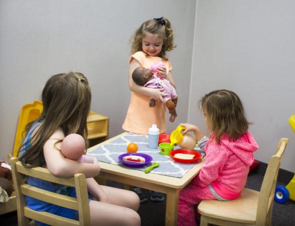 preschool_girls_playing_with_babies_rogys_learning_place_east_peoria_il-589x450