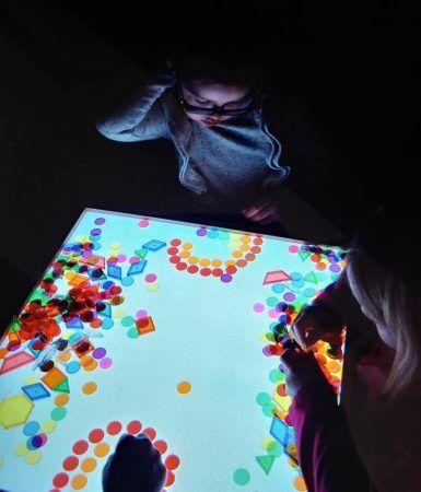 preschool_girls_playing_with_light_table_creative_expressions_learning_center_imperial_mo-385x450