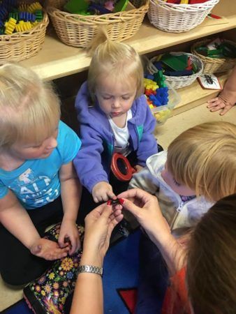 preschool_girls_touching_black_bug_cadence_academy_preschool_milwaukie_portland_or-338x450