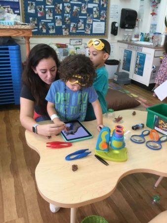 preschooler_and_teacher_playing_on_ipad_cadence_academy_preschool_cranston_ri-338x450