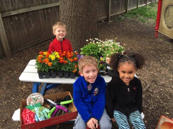 preschooler_excited_about_planting_flowers_cadence_academy_preschool_grand_west_des_moines_ia-600x450