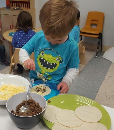 preschooler_making_a_taco_childrens_garden_montessori_richland_wa-395x450