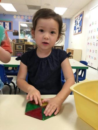 preschooler_playing_with_magnetic_triangles_cadence_academy_preschool_grand_west_des_moines_ia-338x450