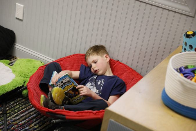 preschooler_reading_book_in_cozy_chair_winwood_childrens_center_leesburg_va-675x450