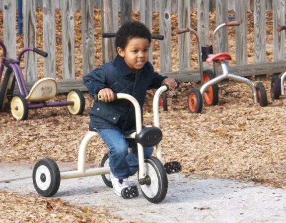 preschooler_riding_tricycle_at_cadence_academy_preschool_summerville_sc-576x450