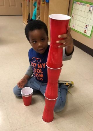 preschooler_stacking_red_solo_cups_cadence_academy_preschool_leon_springs-319x450