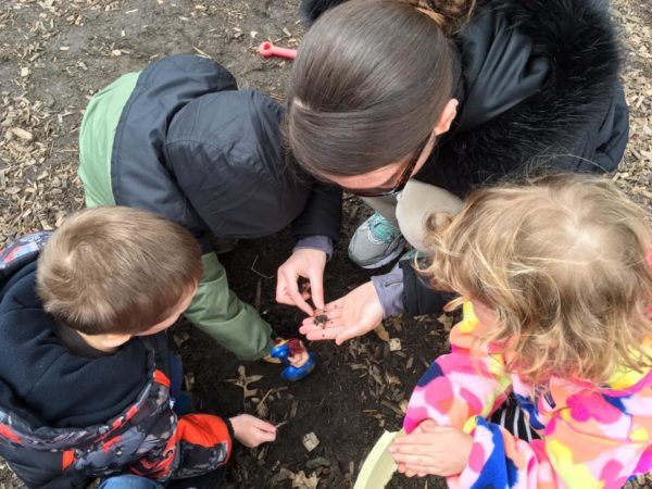 preschoolers_and_teacher_looking_at_worm_on_playground_cadence_academy_preschool_grand_west_des_moines_ia-600x450